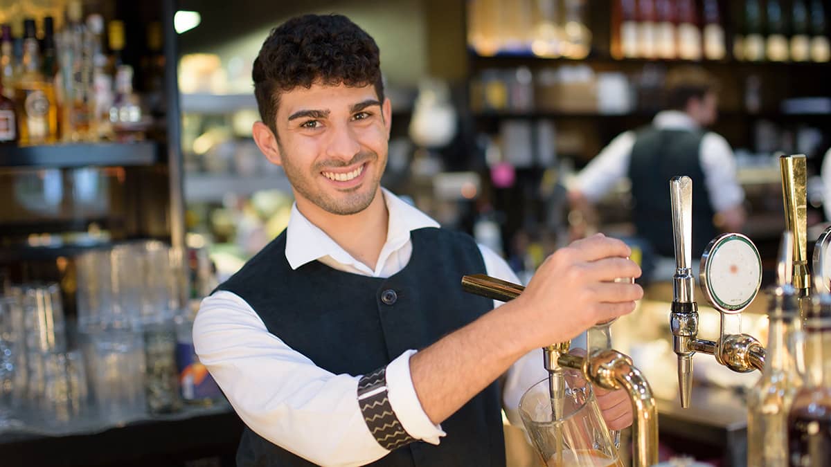 Bar tender pulling a pint in a bar